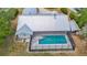 Aerial view showcasing the metal roof, screened-in pool, and surrounding manicured landscape at 1276 Meredith Dr, Spring Hill, FL 34608