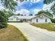 Stunning home exterior with a long driveway, lush landscaping, and a unique architectural style at 1276 Meredith Dr, Spring Hill, FL 34608