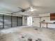 A spacious garage has a work bench, ceiling fan, and plenty of room for storage and parking at 1276 Meredith Dr, Spring Hill, FL 34608