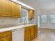 Bright kitchen with wood cabinets, tile backsplash, stainless steel sink, and door to outdoor space at 1276 Meredith Dr, Spring Hill, FL 34608