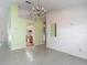 Spacious living room with tile floors, a chandelier, and views into the kitchen and other living spaces at 1276 Meredith Dr, Spring Hill, FL 34608