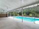 A screened pool overlooks the backyard and mature trees, featuring a patio with fans for relaxed outdoor living at 1276 Meredith Dr, Spring Hill, FL 34608
