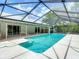 View of a screened-in pool with a geometric screen design and tile accents at 1276 Meredith Dr, Spring Hill, FL 34608