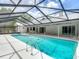 View of a screened-in pool with a geometric screen design and tile accents at 1276 Meredith Dr, Spring Hill, FL 34608