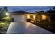 Charming home at dusk, featuring a spacious driveway, two car garage and manicured landscaping at 13100 Fish Cove Dr, Spring Hill, FL 34609