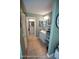 Hallway leading to a bathroom with vanity, mirror and white cabinets at 13100 Fish Cove Dr, Spring Hill, FL 34609