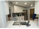 Modern kitchen featuring white cabinets, a stainless steel refrigerator, and a gray backsplash at 13100 Fish Cove Dr, Spring Hill, FL 34609