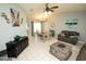 Open-concept living room with tile floors, neutral walls, ceiling fan, dining table, and comfortable furniture at 13100 Fish Cove Dr, Spring Hill, FL 34609