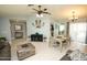Bright living room featuring tile flooring, neutral walls, comfortable furniture, and seamless flow into dining area at 13100 Fish Cove Dr, Spring Hill, FL 34609