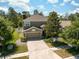 Aerial view of a two-story home featuring a two-car garage and well-manicured landscaping at 18331 Waydale Loop, Hudson, FL 34667
