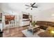 Open-concept living room with hardwood floors and a view of the modern kitchen at 18331 Waydale Loop, Hudson, FL 34667
