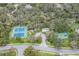 Community aerial view featuring pool, tennis courts, and basketball court amidst wooded landscaping at 18663 Autumn Lake Blvd, Hudson, FL 34667