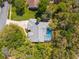 An aerial view of home with a private pool nestled among the trees in a wooded neighborhood at 18663 Autumn Lake Blvd, Hudson, FL 34667