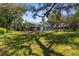 Lush backyard featuring a screened-in lanai, banana trees, and well-maintained lawn for outdoor enjoyment at 18663 Autumn Lake Blvd, Hudson, FL 34667