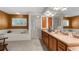 Spacious bathroom with double vanity, stand up shower, large soaking tub, and window for natural light at 18663 Autumn Lake Blvd, Hudson, FL 34667