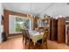 Well-lit dining room featuring hardwood floors, a chandelier, and a view of the landscaped yard at 18663 Autumn Lake Blvd, Hudson, FL 34667