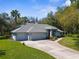 Spacious single-story home featuring a three-car garage, mature landscaping, and well-maintained exterior for inviting curb appeal at 18663 Autumn Lake Blvd, Hudson, FL 34667