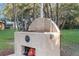 Outdoor stone grill with a lion's head motif adds luxury to outdoor cooking near lush, mature landscaping at 18663 Autumn Lake Blvd, Hudson, FL 34667