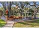 Outdoor picnic area featuring wooden tables, ample seating and BBQ, perfect for outdoor gatherings in the community at 18663 Autumn Lake Blvd, Hudson, FL 34667