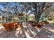 Outdoor picnic area featuring wooden tables, ample seating, and mature trees, perfect for gatherings and relaxation at 18663 Autumn Lake Blvd, Hudson, FL 34667