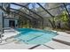 A bright, screened-in pool with a tiled edge and metal railing for easy access at 18663 Autumn Lake Blvd, Hudson, FL 34667