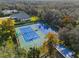Aerial view of well-maintained tennis courts surrounded by lush greenery, offering a great recreational amenity at 18663 Autumn Lake Blvd, Hudson, FL 34667