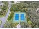 Aerial view of the community's blue tennis courts surrounded by lush green landscaping at 18663 Autumn Lake Blvd, Hudson, FL 34667