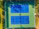Overhead shot of bright blue and green tennis courts, offering a fantastic recreational amenity with mature trees for shade at 18663 Autumn Lake Blvd, Hudson, FL 34667