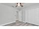 A clean bedroom with light gray walls, wood-look floors, a ceiling fan, and a double-door closet at 2431 Murray Pass, Odessa, FL 33556