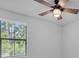 Bright bedroom featuring a ceiling fan and view of nature through a window at 2431 Murray Pass, Odessa, FL 33556