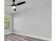 Bedroom featuring gray walls, wood-look floors, a ceiling fan, and a window with blinds at 2431 Murray Pass, Odessa, FL 33556