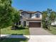 Charming home featuring a stone facade, a two car garage, and landscaped front yard at 2431 Murray Pass, Odessa, FL 33556