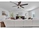 Bright living room with a sectional sofa, ceiling fan, stylish decor, and modern furniture at 2431 Murray Pass, Odessa, FL 33556