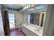 Well-lit bathroom featuring a double sink vanity, walk in shower and decorative trim at 2538 Indigo Dr, Dunedin, FL 34698
