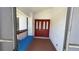 Covered front entrance with a screen door and a bench with a blue cushion at 2538 Indigo Dr, Dunedin, FL 34698