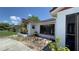 Home exterior featuring a large window and a small manicured garden at 2538 Indigo Dr, Dunedin, FL 34698