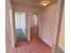 Hallway with tile flooring leading to various rooms with interior doors at 2538 Indigo Dr, Dunedin, FL 34698