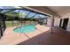 Screened-in pool area surrounded by a large patio and green backyard space at 2538 Indigo Dr, Dunedin, FL 34698