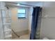 Tiled shower with glass block detail and a blue shower curtain at 2538 Indigo Dr, Dunedin, FL 34698