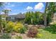 A backyard with mature trees and flowering plants provides privacy around the screened lanai at 2924 Windridge Dr, Holiday, FL 34691