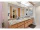 Bathroom with a long vanity, double sinks, large mirrors, and bright lighting at 2924 Windridge Dr, Holiday, FL 34691