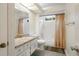 Bright bathroom with white cabinets, granite countertops, and a shower-tub combo at 2924 Windridge Dr, Holiday, FL 34691