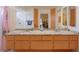 Bathroom featuring double sinks with orange cabinets and a view of the shower at 2924 Windridge Dr, Holiday, FL 34691