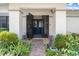 Inviting front entrance with secure iron gates and a beautifully landscaped garden at 2924 Windridge Dr, Holiday, FL 34691