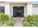 Welcoming front entrance with decorative iron security gate and lush tropical landscaping at 2924 Windridge Dr, Holiday, FL 34691