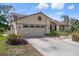 Spacious two-car garage with decorative window and lush landscaping along the driveway at 2924 Windridge Dr, Holiday, FL 34691