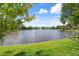 A stunning lake view with a fountain is framed by lush greenery from the grassy shoreline at 2924 Windridge Dr, Holiday, FL 34691