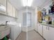 Functional laundry room featuring white cabinets, washer, and dryer for convenient chores at 2924 Windridge Dr, Holiday, FL 34691