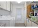 Functional laundry room featuring white cabinets, washer, and dryer for convenient chores at 2924 Windridge Dr, Holiday, FL 34691