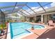 Enjoy the Florida sun in this screened-in pool with a spacious deck and lush landscaping at 2924 Windridge Dr, Holiday, FL 34691